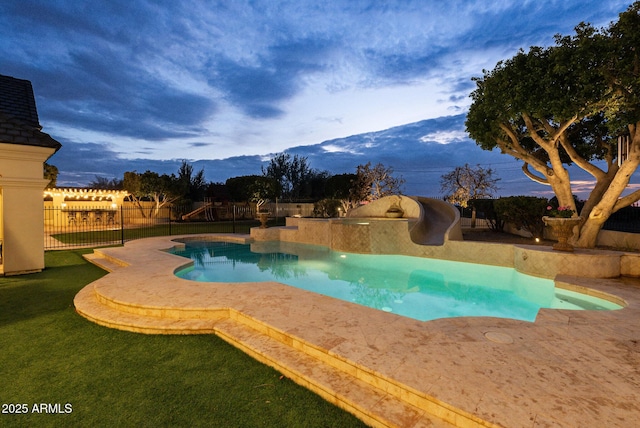 view of swimming pool with a mountain view, a lawn, and a water slide