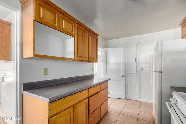 813 N Gilbert Ave, Casa Grande, AZ 85122 - kitchen with freestanding refrigerator, stove, light tile patterned floors, and dark countertops
