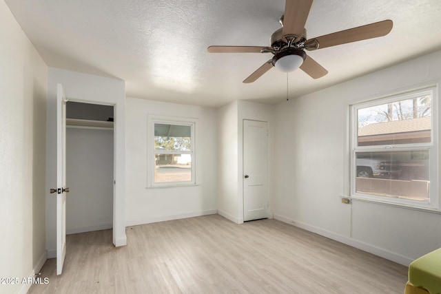 813 N Gilbert Ave, Casa Grande, AZ 85122 - unfurnished bedroom featuring light wood-style floors, a textured ceiling, baseboards, and multiple windows