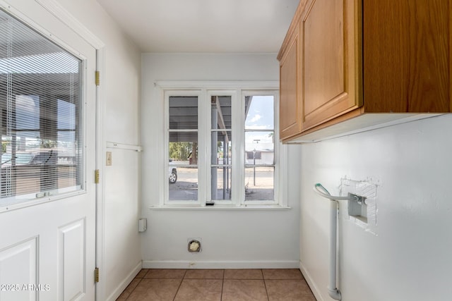 813 N Gilbert Ave, Casa Grande, AZ 85122 - clothes washing area with baseboards, cabinet space, and light tile patterned flooring