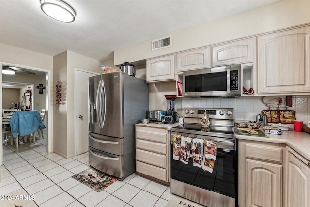 kitchen with backsplash, light brown cabinets, and stainless steel appliances