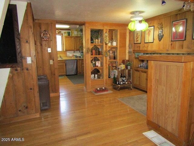 hallway with visible vents, wood walls, and light wood-type flooring