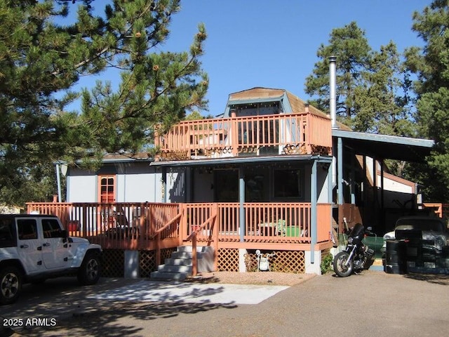 view of front facade featuring a carport, a balcony, and a wooden deck