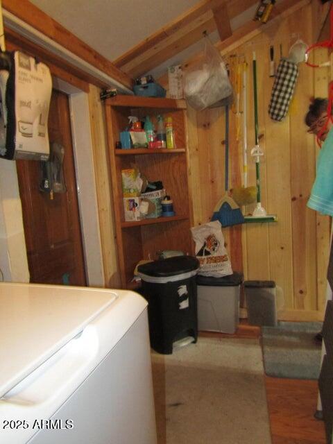 interior space featuring washer / dryer, wooden walls, and laundry area