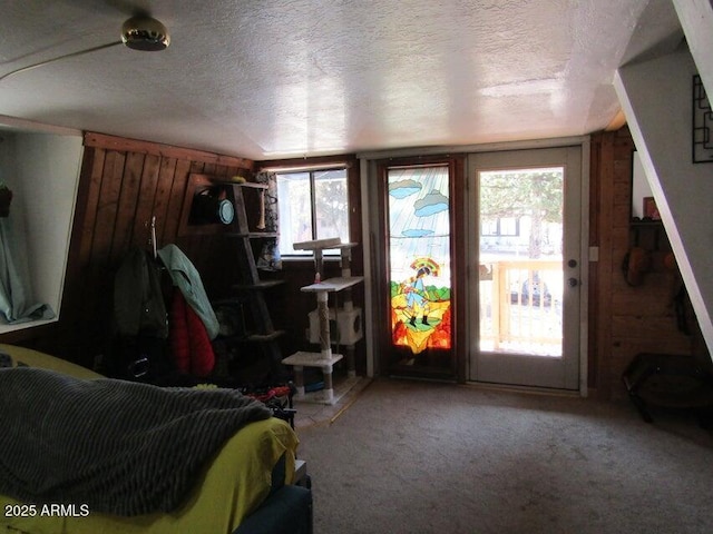 bedroom with a textured ceiling, carpet, and access to outside