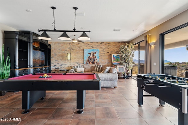 recreation room with pool table, brick wall, and tile patterned flooring