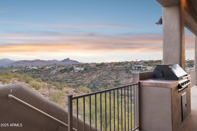 balcony at dusk featuring a mountain view