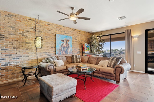 living room featuring ceiling fan, brick wall, and tile patterned flooring