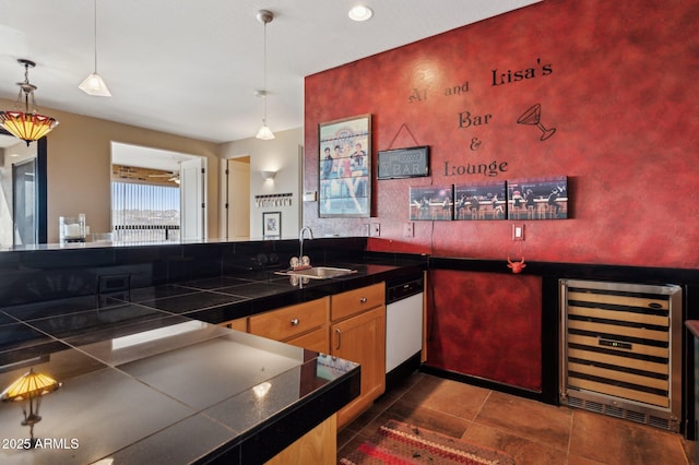 kitchen featuring sink, decorative light fixtures, beverage cooler, and dishwasher