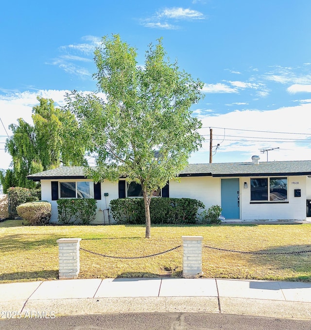 single story home featuring a front lawn