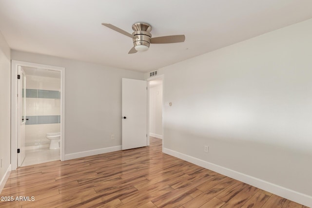 unfurnished bedroom with visible vents, light wood-style floors, a ceiling fan, ensuite bath, and baseboards