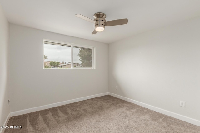 carpeted empty room with baseboards and a ceiling fan