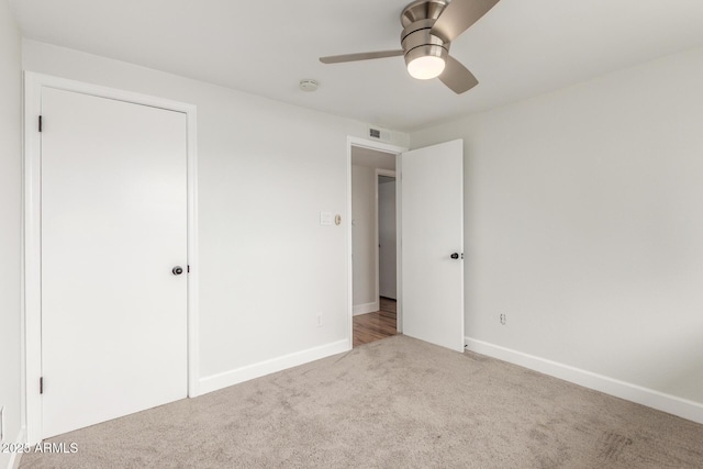 unfurnished bedroom with carpet floors, baseboards, visible vents, and a ceiling fan