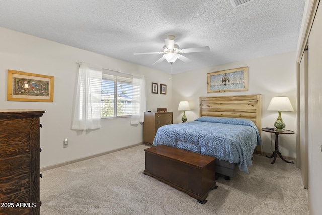 carpeted bedroom featuring ceiling fan, a closet, and a textured ceiling