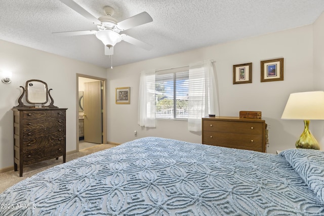 bedroom with ceiling fan, light colored carpet, and a textured ceiling