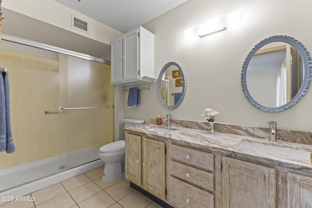 bathroom with vanity, a shower with shower door, tile patterned floors, and toilet