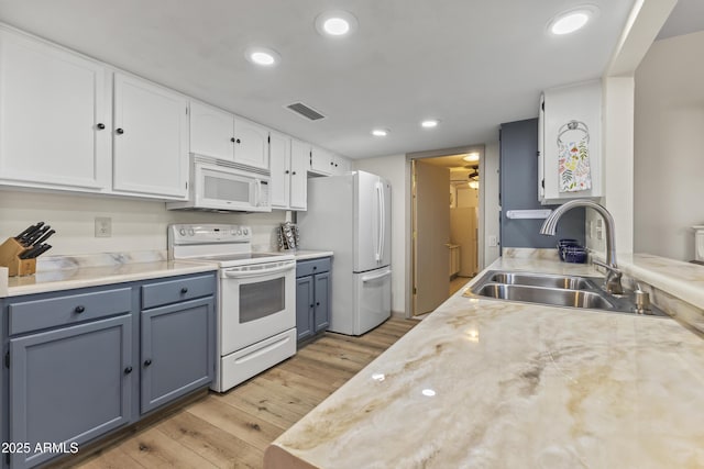 kitchen with sink, light wood-type flooring, white cabinets, ceiling fan, and white appliances