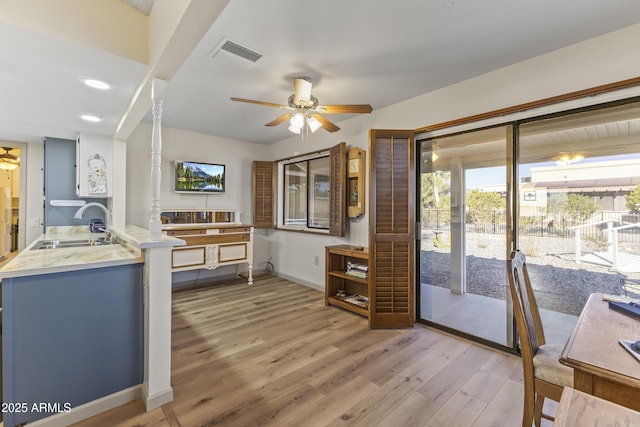 interior space with sink, hardwood / wood-style flooring, kitchen peninsula, and ceiling fan