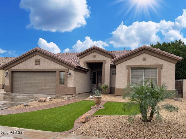 mediterranean / spanish house featuring stucco siding, concrete driveway, an attached garage, and a tile roof