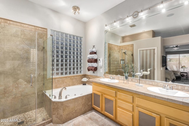 ensuite bathroom featuring a tub with jets, a sink, a shower stall, tile patterned floors, and connected bathroom