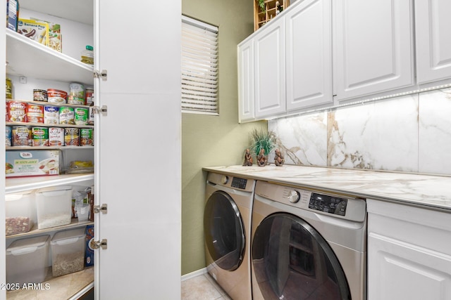 laundry room featuring light tile patterned floors, cabinet space, and washing machine and dryer