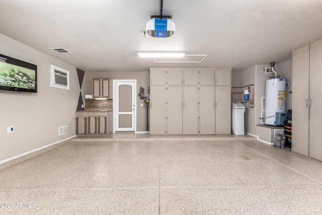 garage featuring visible vents, a garage door opener, water heater, and baseboards