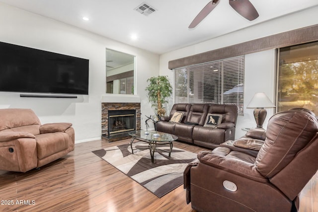 living area featuring visible vents, ceiling fan, a stone fireplace, recessed lighting, and wood finished floors