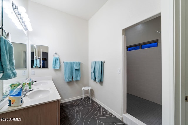 bathroom featuring vanity, tile patterned flooring, and a tile shower