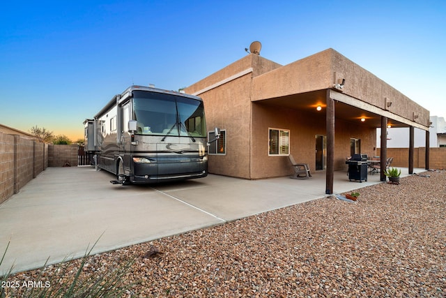 property exterior at dusk with a patio area