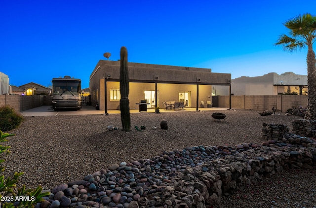 back of property featuring an outdoor fire pit and a patio area