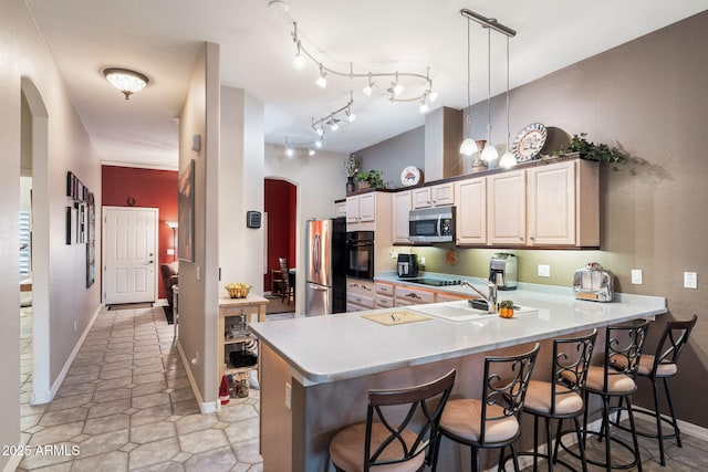 kitchen featuring hanging light fixtures, black appliances, kitchen peninsula, and a kitchen bar