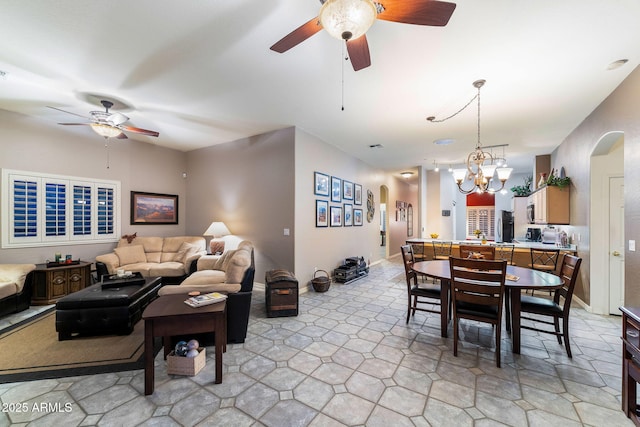 living room featuring ceiling fan with notable chandelier