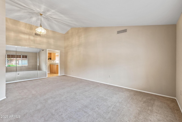 carpeted empty room with high vaulted ceiling, baseboards, a chandelier, and visible vents