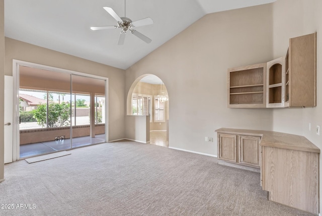 unfurnished living room with arched walkways, baseboards, high vaulted ceiling, a ceiling fan, and carpet floors