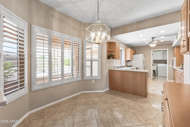 kitchen with a wealth of natural light, washer / clothes dryer, open shelves, and freestanding refrigerator