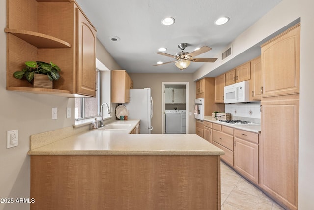 kitchen featuring open shelves, a sink, white appliances, visible vents, and independent washer and dryer