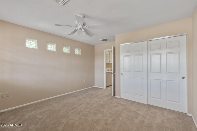 unfurnished bedroom featuring a ceiling fan, a closet, light colored carpet, baseboards, and visible vents
