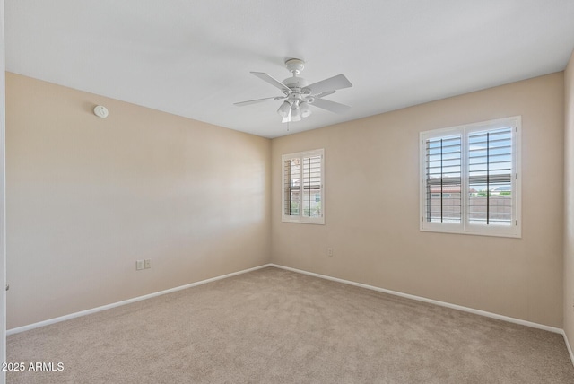spare room featuring ceiling fan, baseboards, and carpet
