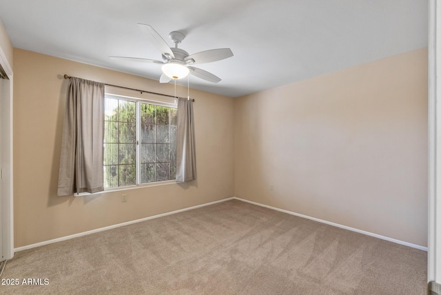 carpeted spare room featuring baseboards and ceiling fan