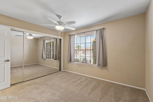 unfurnished bedroom with baseboards, carpet floors, a ceiling fan, and a closet