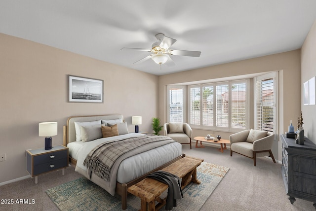 carpeted bedroom with ceiling fan and baseboards