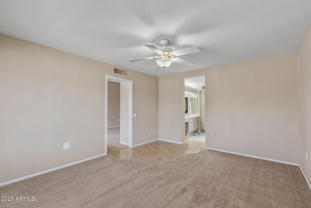 spare room with baseboards, visible vents, carpet, and ceiling fan