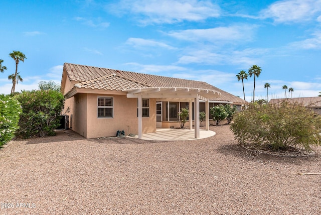 rear view of house featuring central AC, a tile roof, a pergola, a patio, and stucco siding