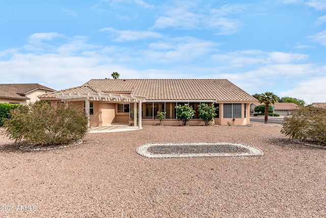 back of house with stucco siding, a tile roof, a pergola, and a patio area