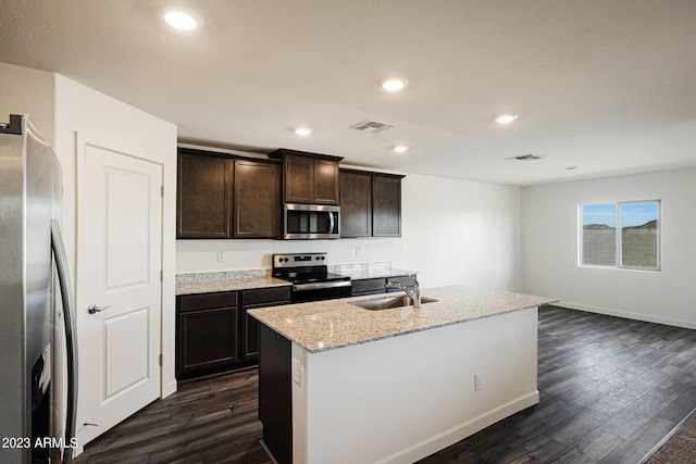 kitchen featuring sink, dark brown cabinets, dark hardwood / wood-style flooring, stainless steel appliances, and a kitchen island with sink