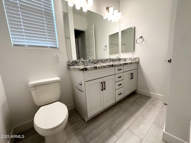 5923 N 85th Ave, Glendale, AZ 85305 - full bathroom with double vanity, wood finished floors, a sink, baseboards, and toilet