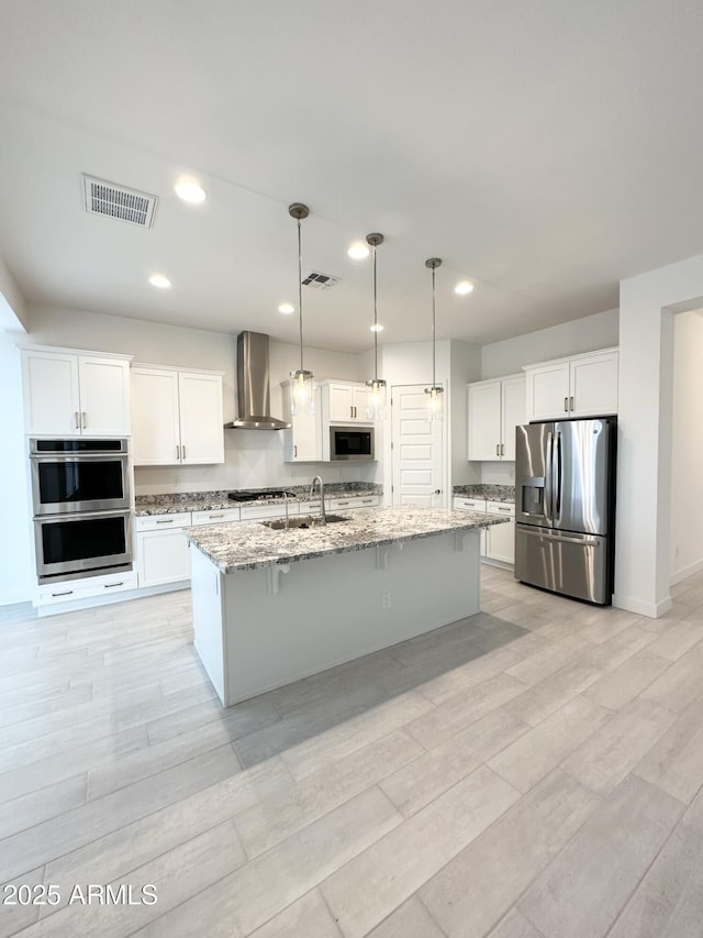 5923 N 85th Ave, Glendale, AZ 85305 - kitchen featuring visible vents, a sink, appliances with stainless steel finishes, and wall chimney range hood