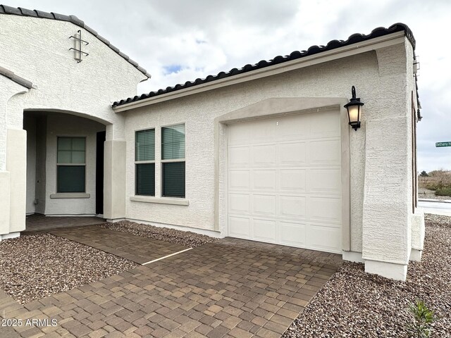 5923 N 85th Ave, Glendale, AZ 85305 - exterior space featuring decorative driveway, an attached garage, a tile roof, and stucco siding