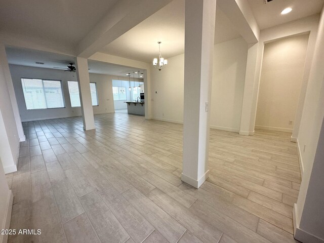 5923 N 85th Ave, Glendale, AZ 85305 - unfurnished living room featuring baseboards, light wood-style flooring, and ceiling fan with notable chandelier