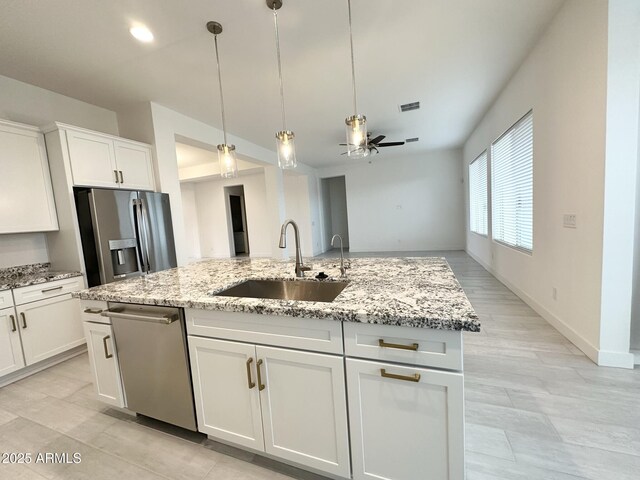5923 N 85th Ave, Glendale, AZ 85305 - kitchen featuring light stone counters, a sink, stainless steel appliances, a ceiling fan, and visible vents